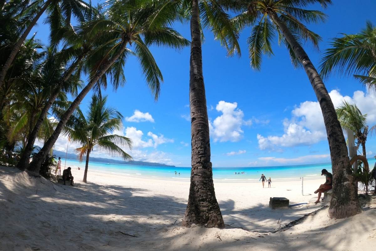 Soft white sand and palm trees on White Beach in Boracay Island, Philippines