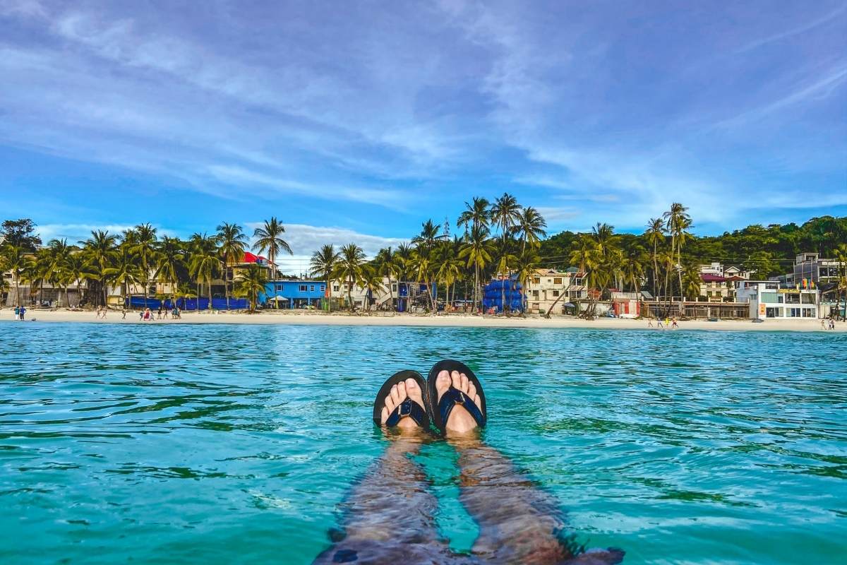 My friends feet swimming in Boracay Island looking back at Whites Beach